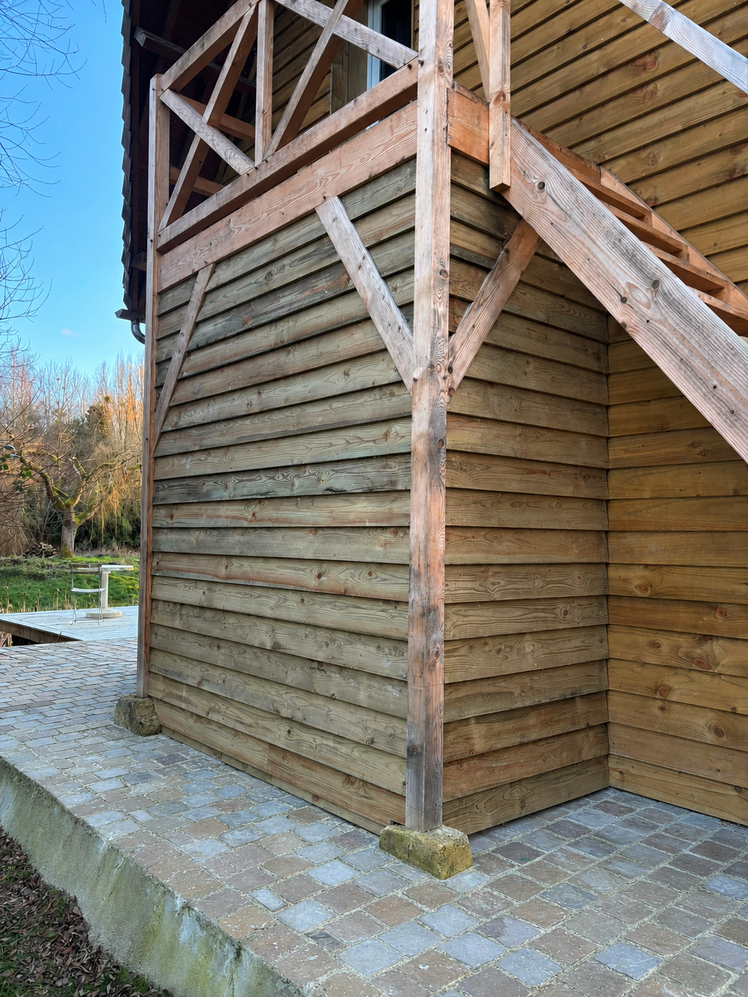 Bardage bois et structure sur pilotis sur pavés
