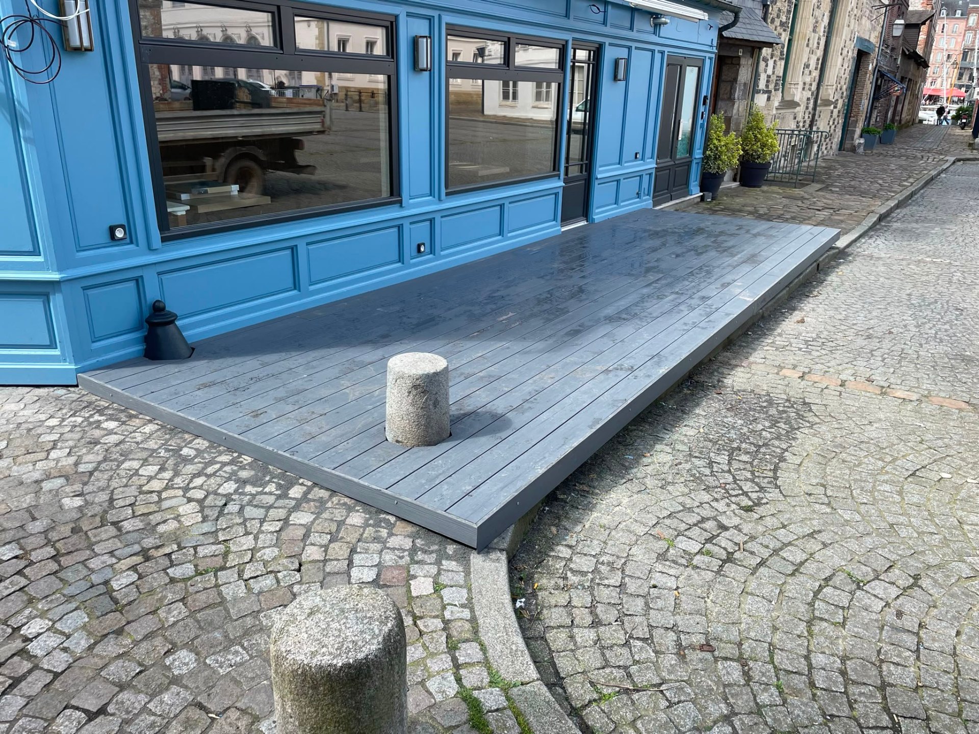 Terrasse composite grise sur pavés d'un port