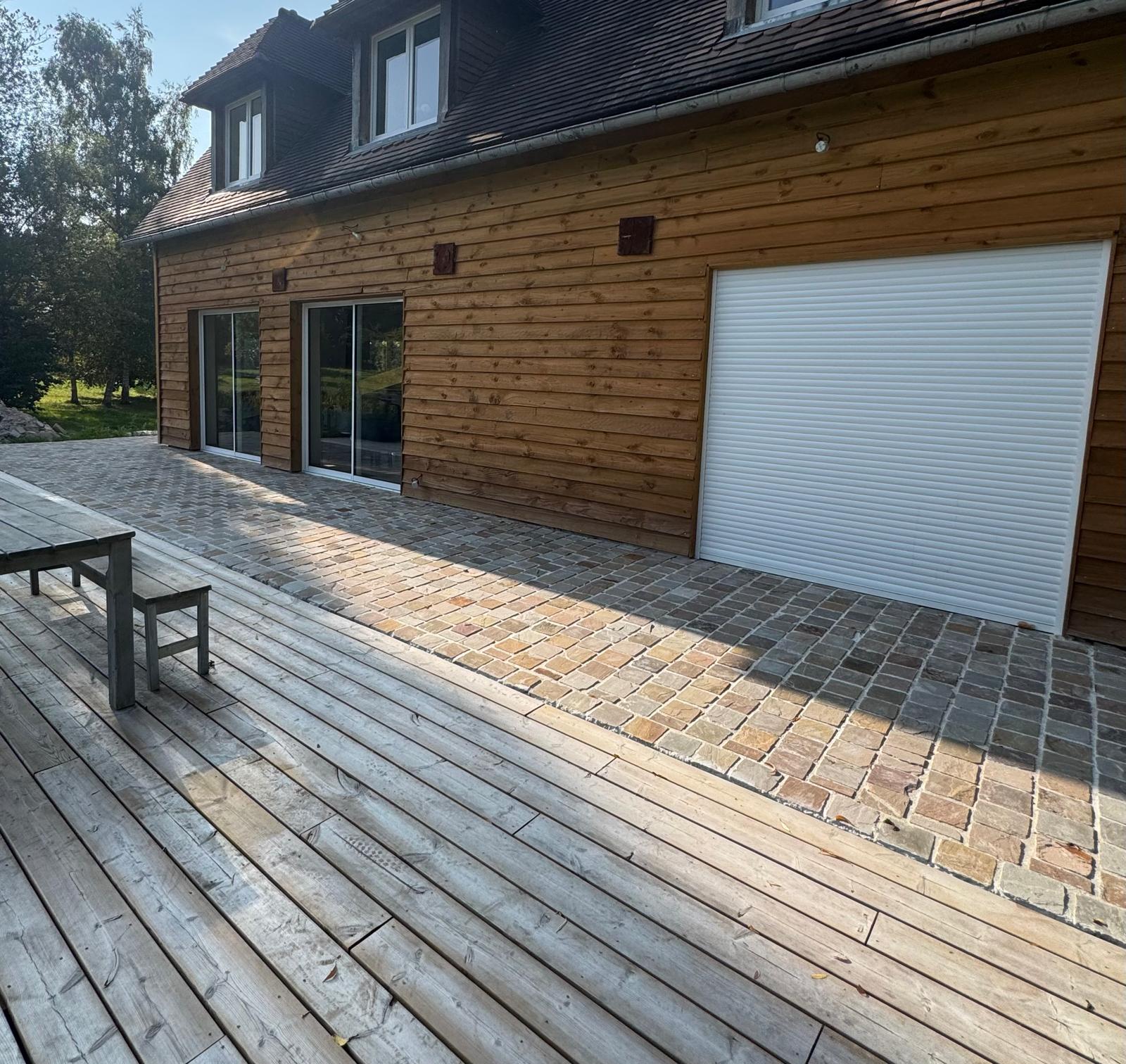 Dallage pavé et terrasse bois le long d'une façade
