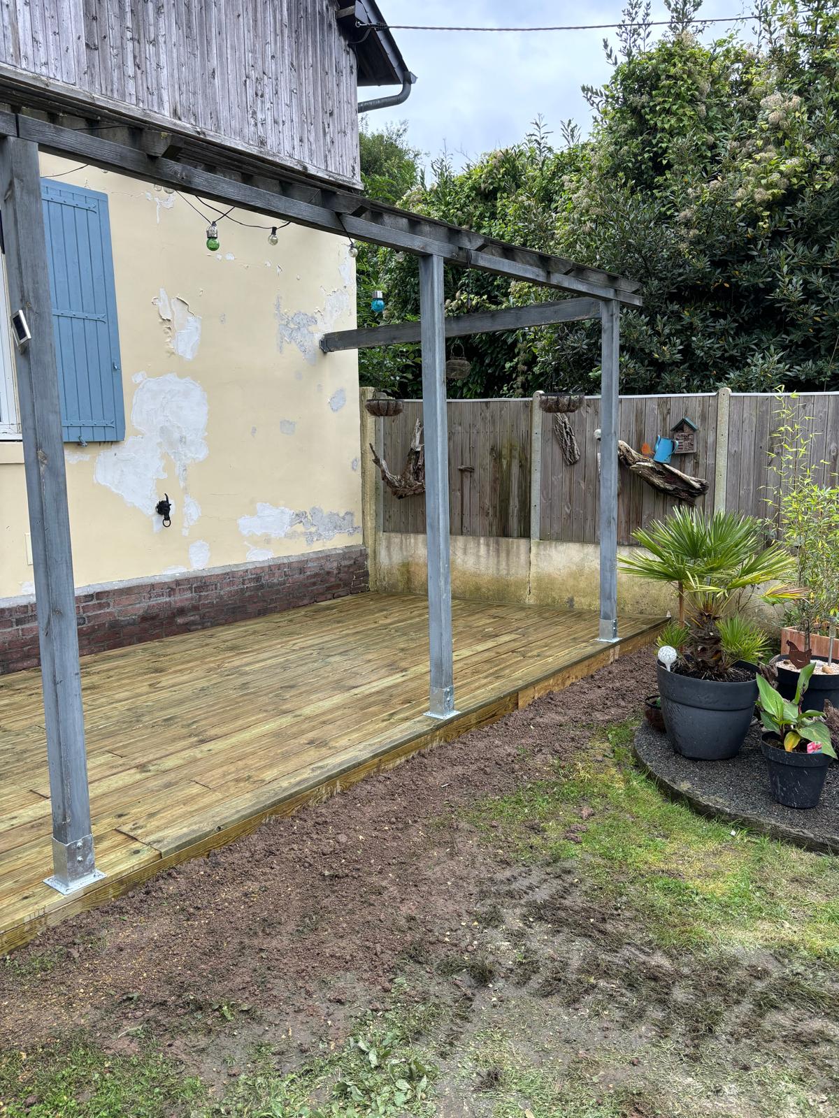 Terrasse bois sous pergola à poteaux métalliques