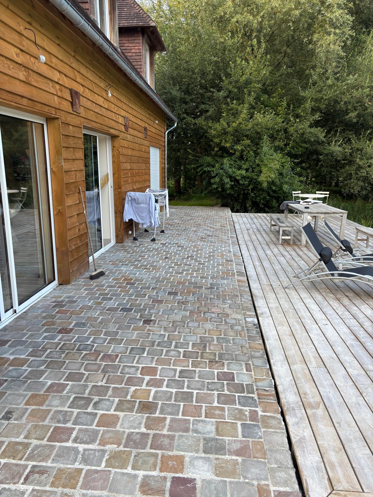 Pavés en grès bordant une terrasse en bois