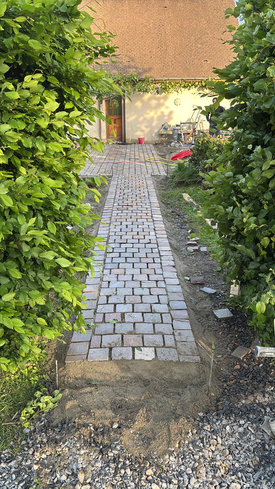 Allée en pavés anciens entre deux haies
